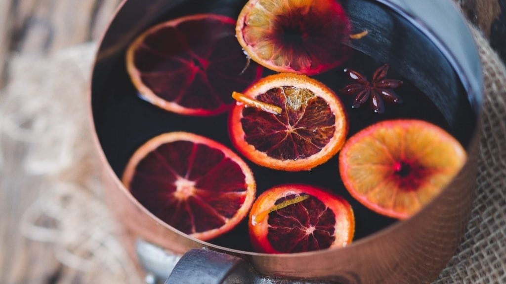 A pan brewing mulled wine with slices of oranges