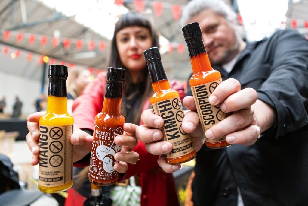 people-holding-range-of-hot-sauce-bottles-at-hot-sauce-society-which-comes-to-birmingham