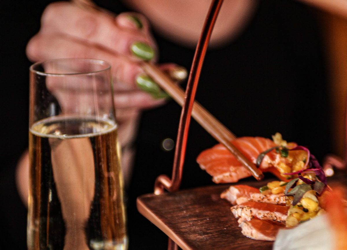 woman-taking-sashimi-off-tier-with-chopsticks