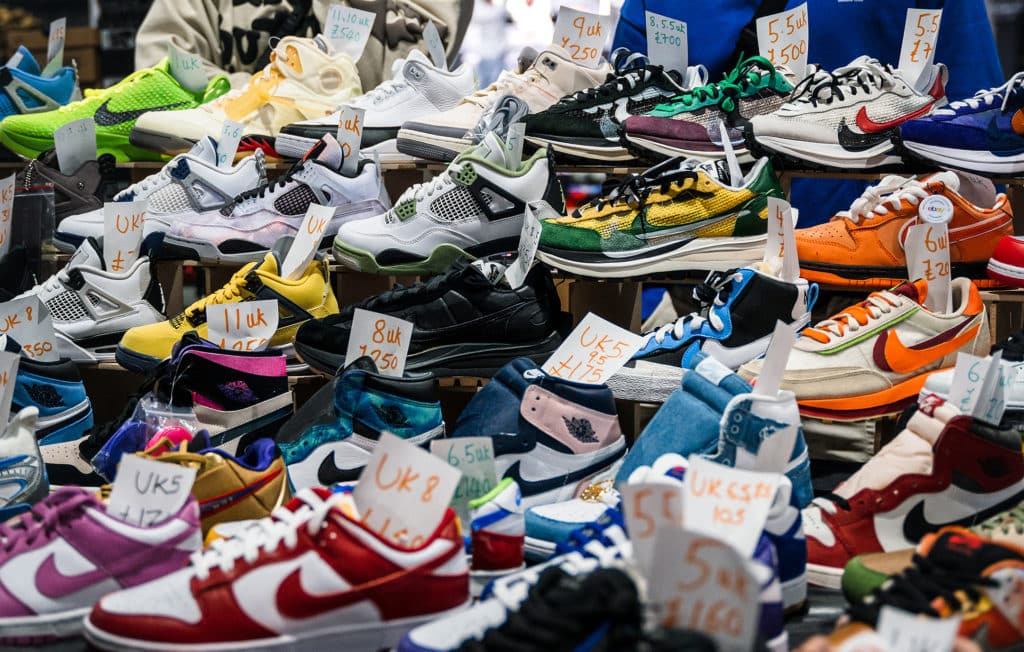 A stall at Crepe City displaying a variety of Nike Dunks, Jordan 4s, Sacai x Nike Vaporwaffles, and other trainers
