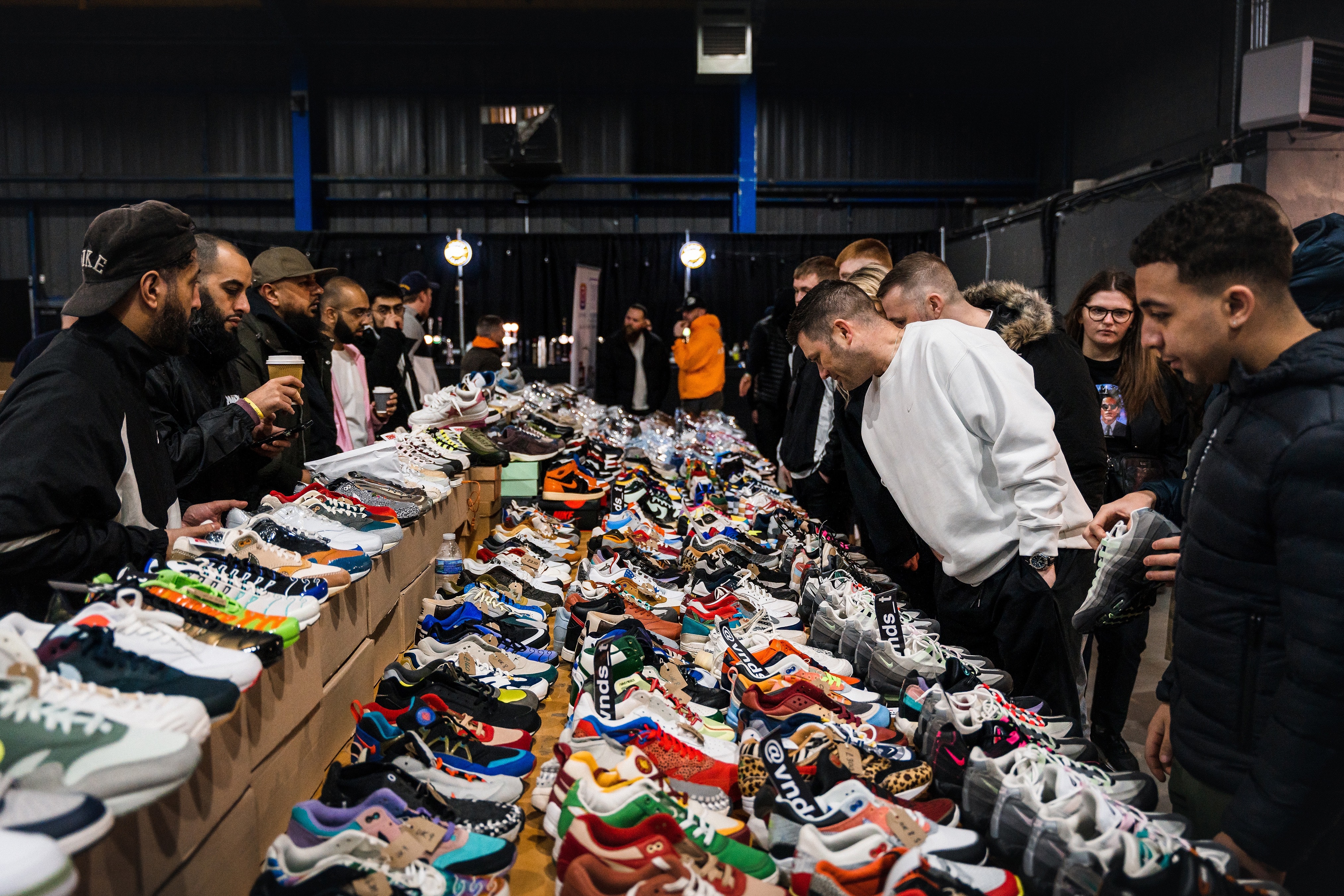 Customers inspecting trainers on a stall at Crepe City