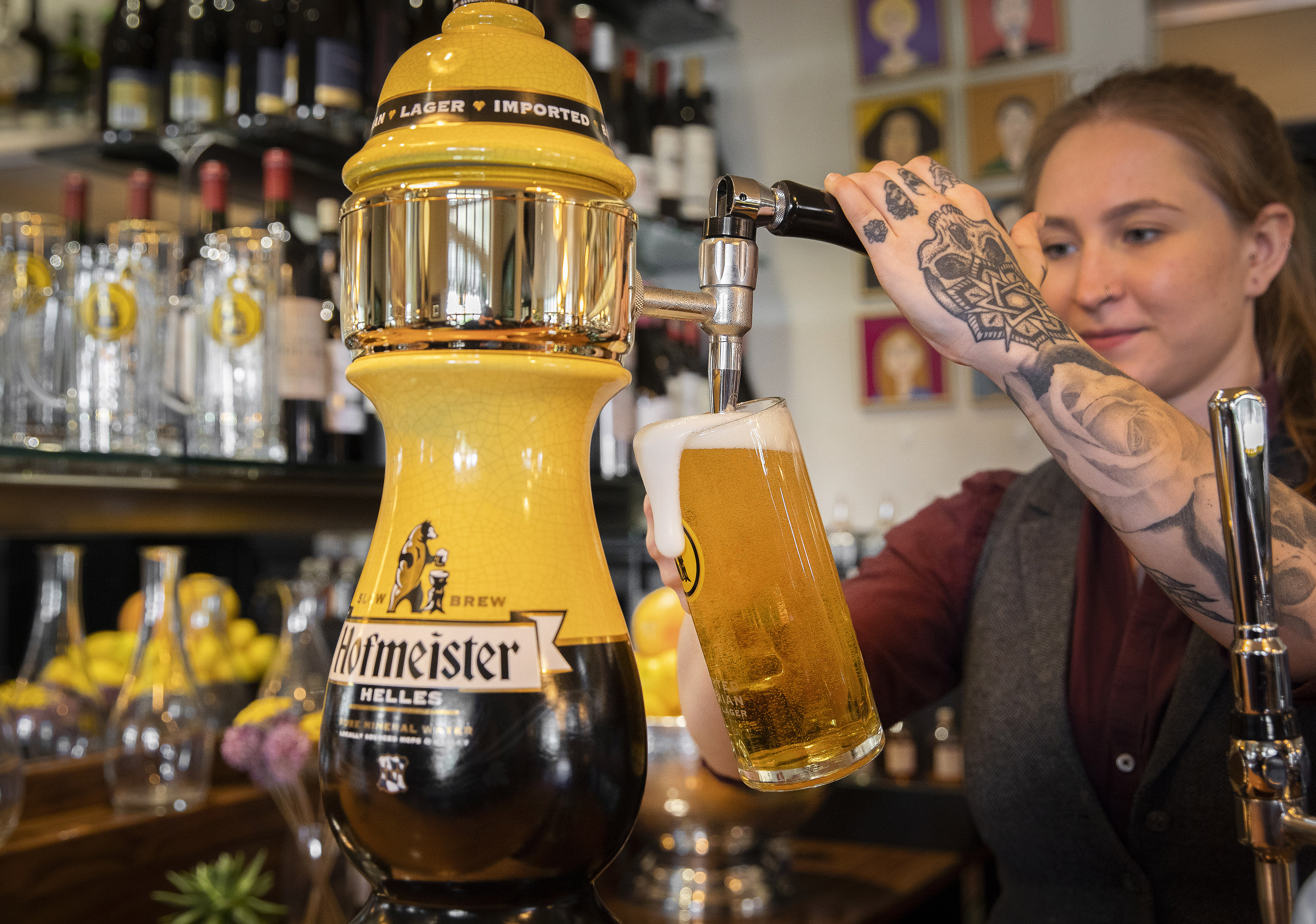 A woman pouring a stein of German lager, Hofmeister, at Oktoberfest