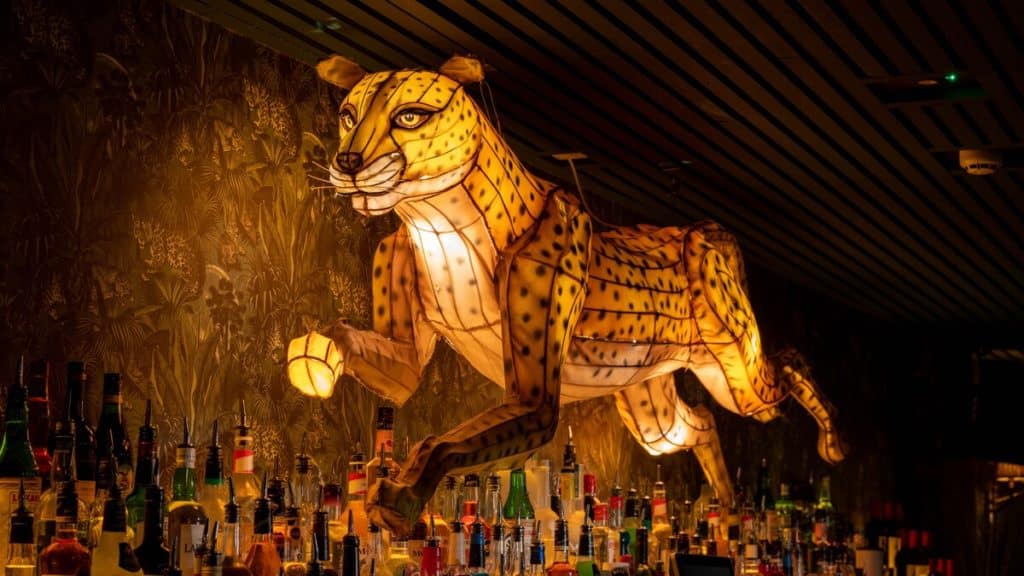 A lit up cheetah on the wall of the cocktail club