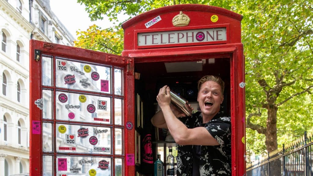 World's smallest cocktail bar in a phone box, with a bartender making drinks