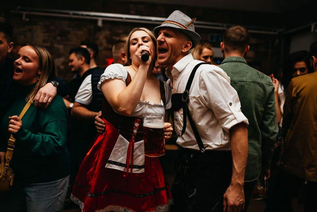 A woman and a man singing dressed in lederhosen