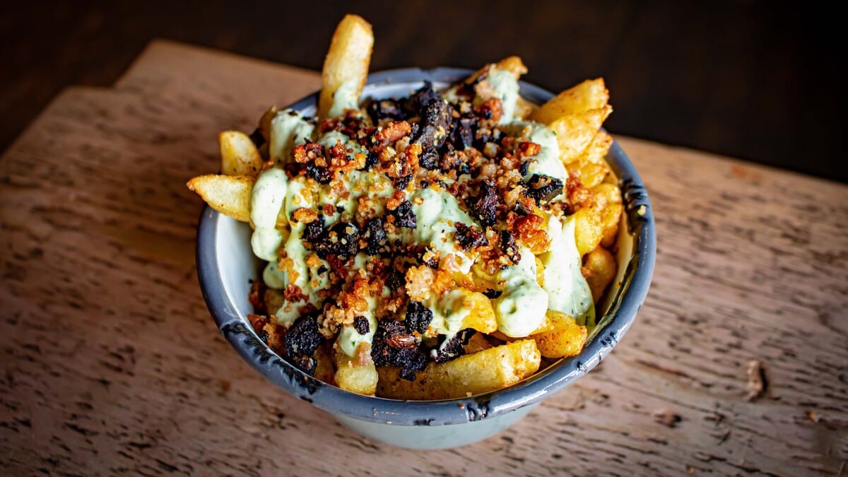 Hand cut chips topped with black pudding and bacon bits from Fat Hippo