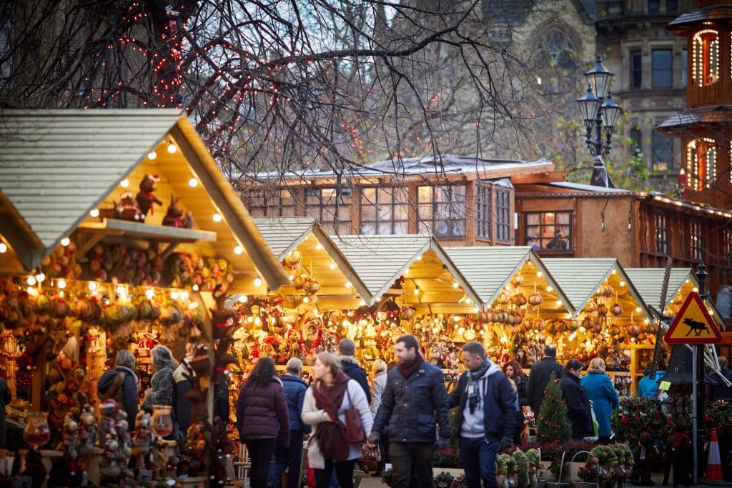 Shoppers looking around christmas market stalls