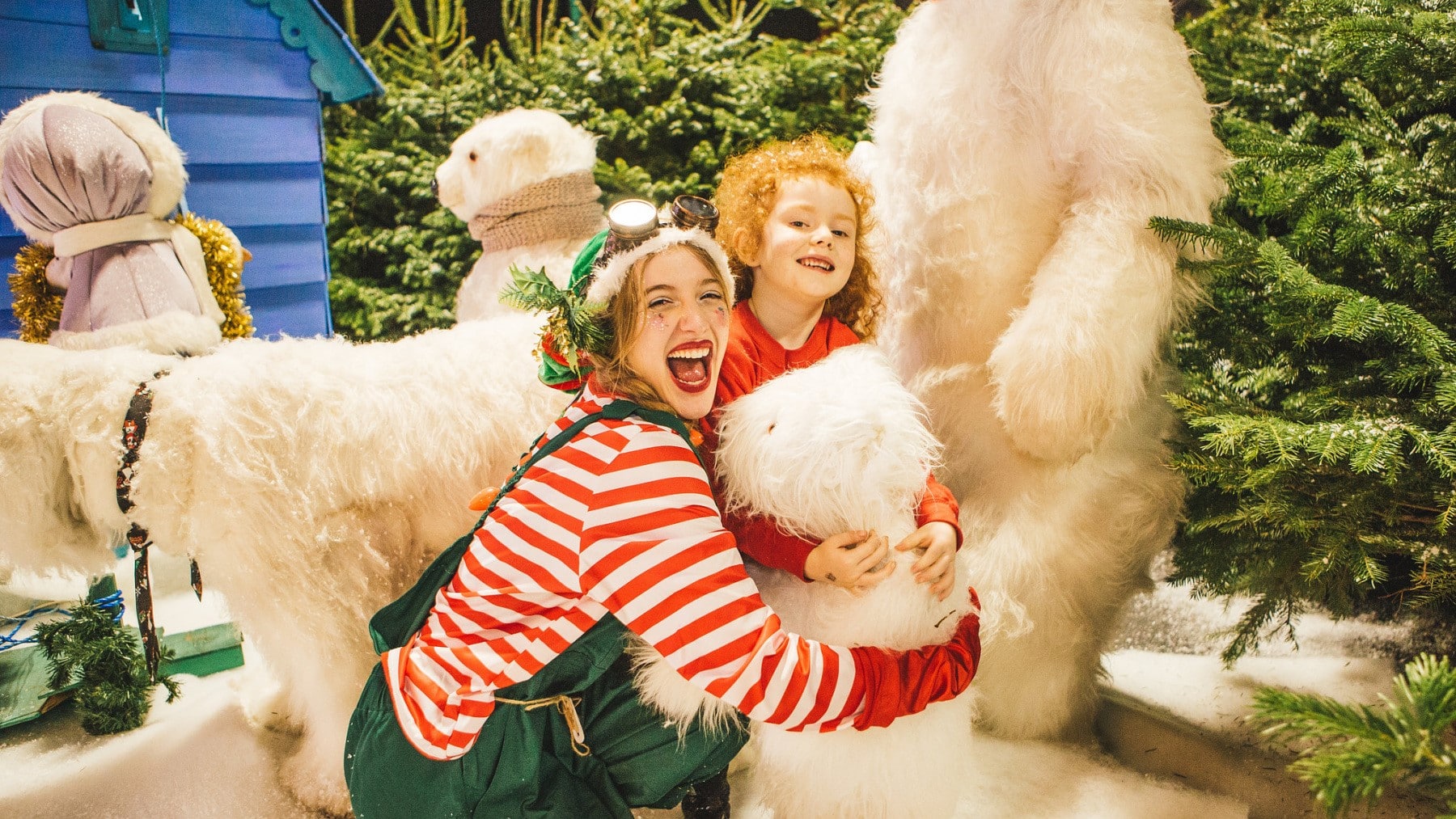 A Christmas elf with a young girl surrounded by Chrtimas trees and polar bears at Winter Funland