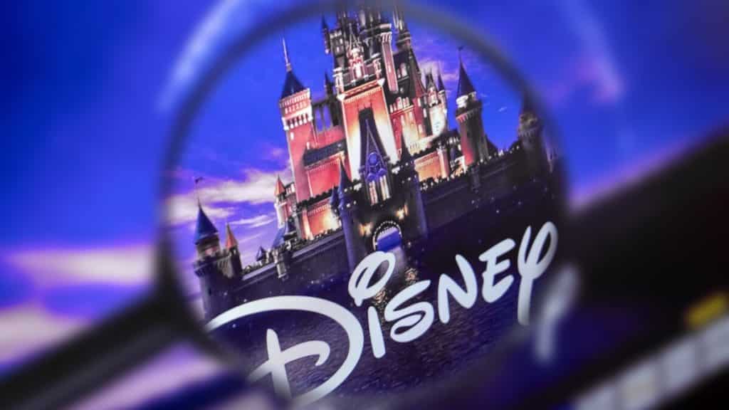 Disney 100: The home page of the Disney site, view through a magnifying glass. Disney company logo is visible. Soft focus.