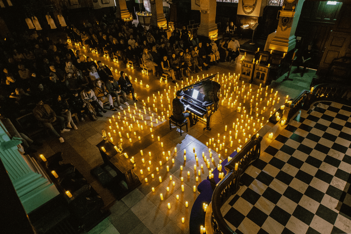 Birmingham Cathedral illuminated by candles while a pianist plays