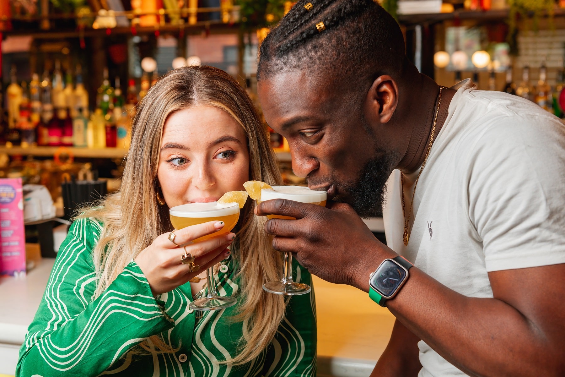 A man and a woman drinking a rum cocktail from Revolucion de Cuba