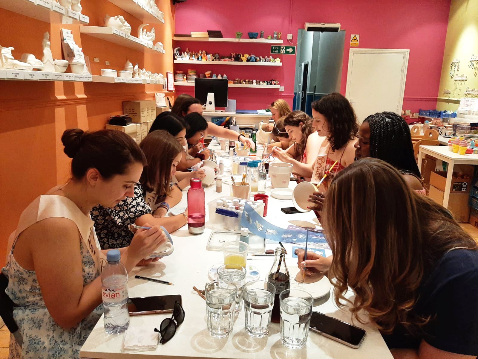 A group of women sat around painting ceramics inside Cafe Craft