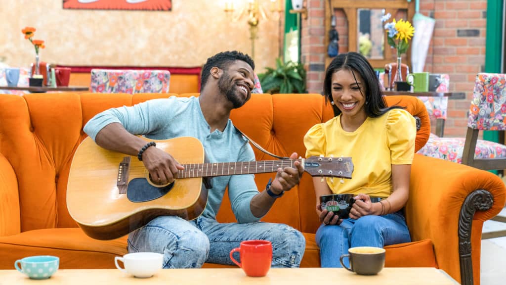 a man serenading a woman with a guitar at The FRIENDS™ Experience