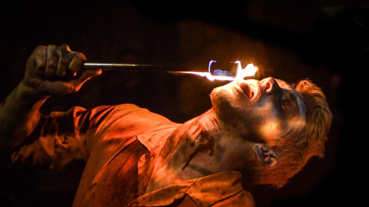 A man licking a flaming torch at the scare maze in Luna Springs